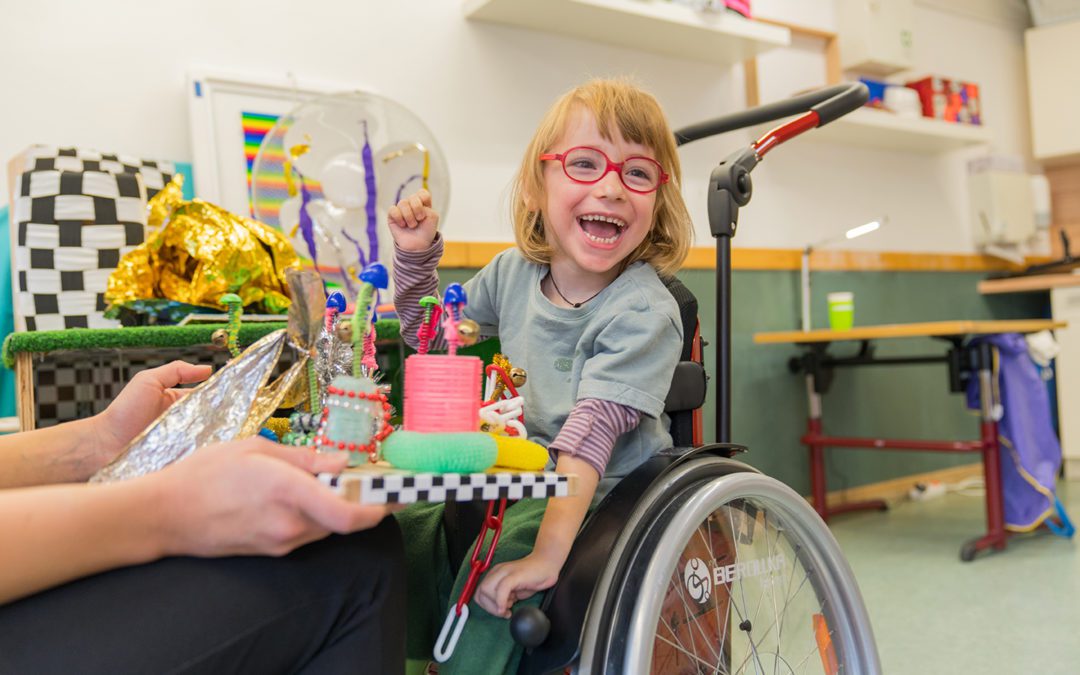Kind im Astrid-Lindgren-Haus von Körperbehinderte Allgäu freut sich über Spielsachen.