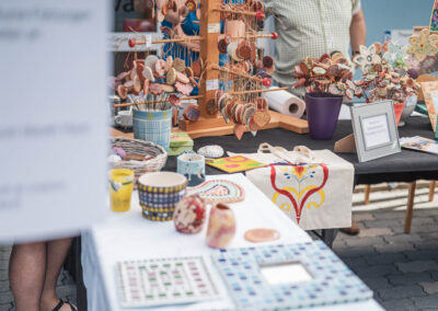 Ein Marktstand mit vielen bunten Gegenständen wie selbstgemachten Anhängern.