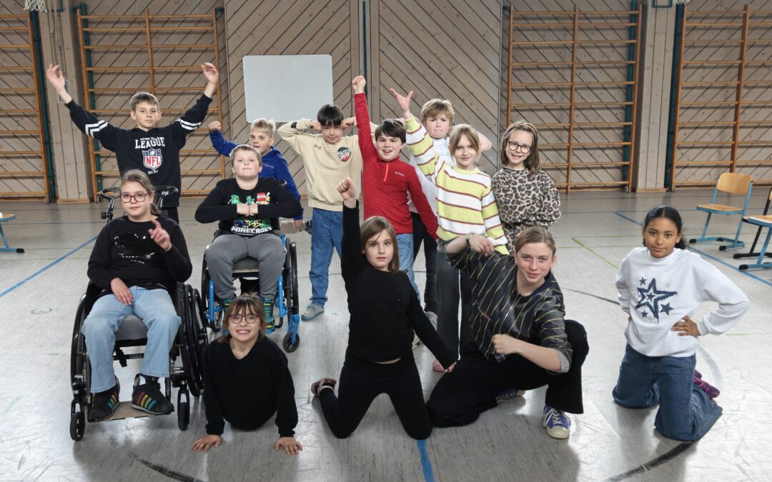 Eine Gruppe Kinder des inklusiven Theaterprojektes machen eine MUt-Pose